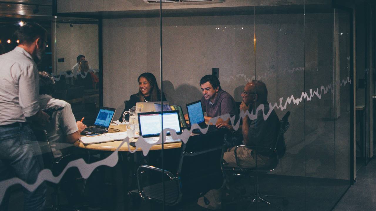 Several workers laughing together in a conference room