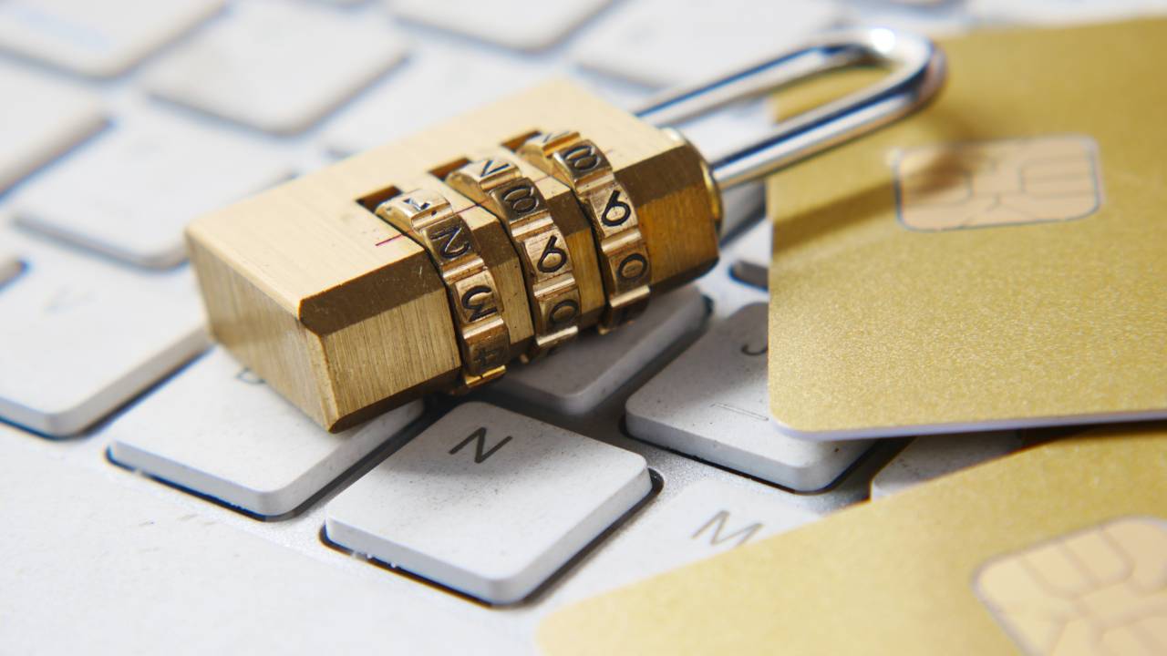 A golden lock with numbers placed on a white keyboard